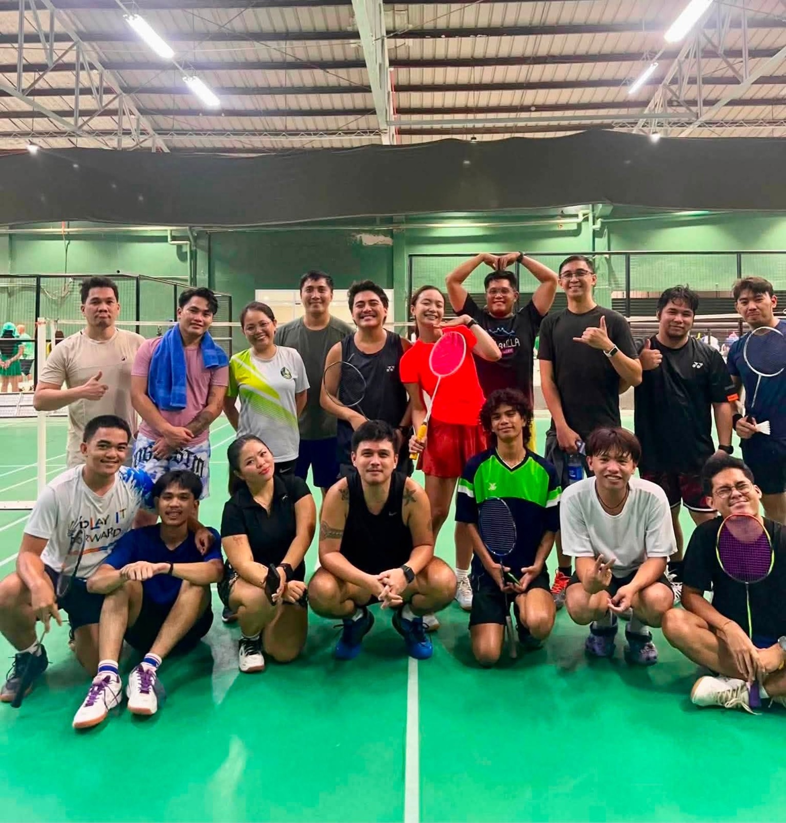 A badminton group gathering on court at Hoops & Racket