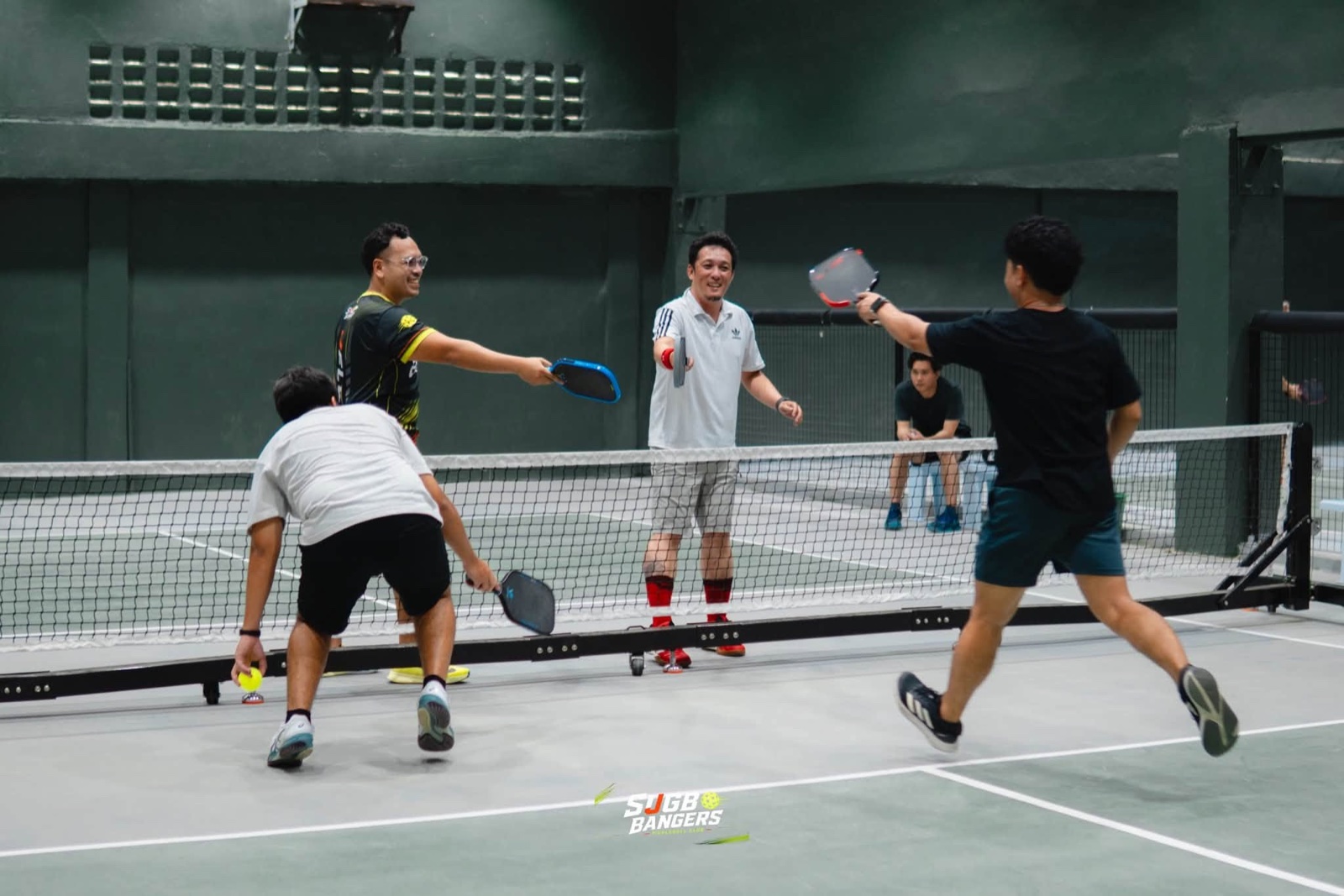 Four pickleball players meeting at the net during a game